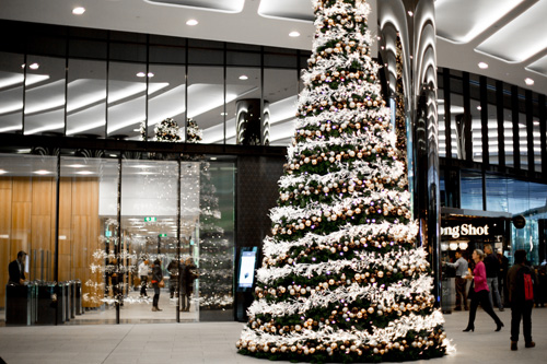 A decorated Christmas tree at the entrance to a foyer at Collins Square