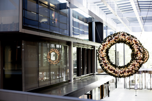 Lit-up Christmas wreaths hanging in a Collins Square atrium