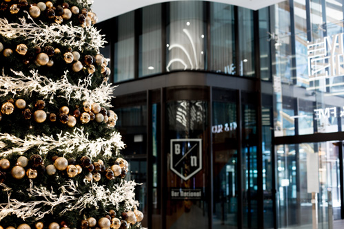 A decorated Christmas tree at the entrance to a modern office building